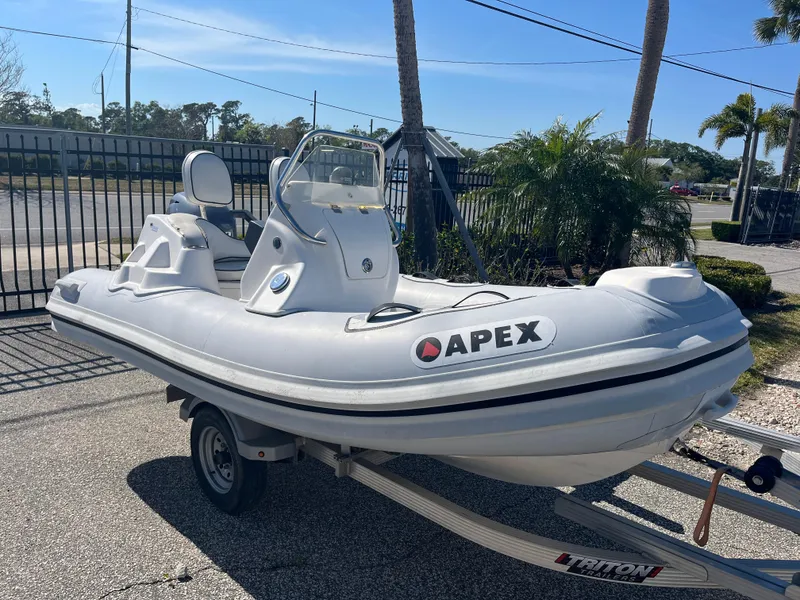 Slide: The Image of 2014 Apex A-11 Tender inflatable boat on trailer, parked outdoors. - 2