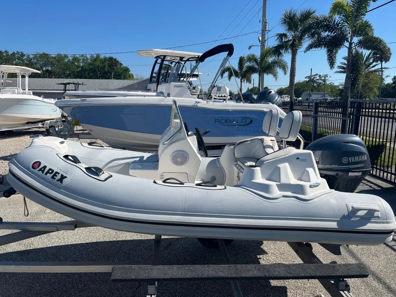 Slide: The Image of 2014 Apex A-11 Tender boat displayed outdoors with other vessels. - 5