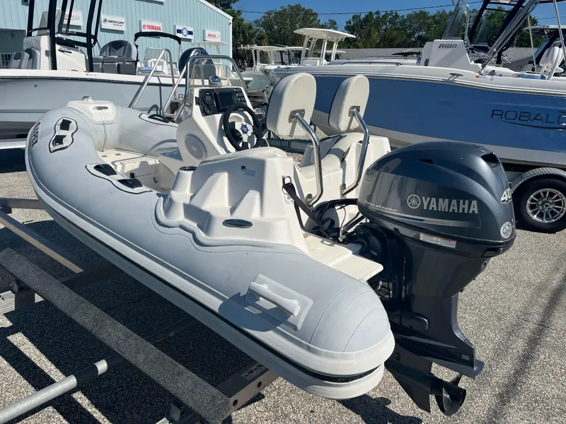 Slide: The Image of 2014 Apex A-11 Tender boat with Yamaha outboard motor, displayed on a trailer. - 6