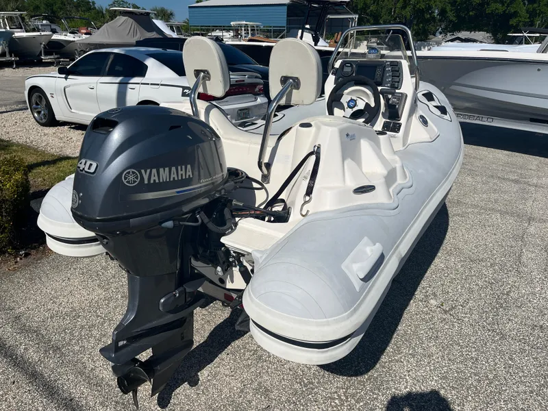 Slide: The Image of 2014 Apex A-11 Tender boat with Yamaha 40HP outboard motor, parked on gravel. - 8