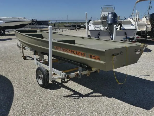 Slide: The Image of 2025 Tracker Grizzly® 15 Jon boat on trailer in a marina setting. - 4