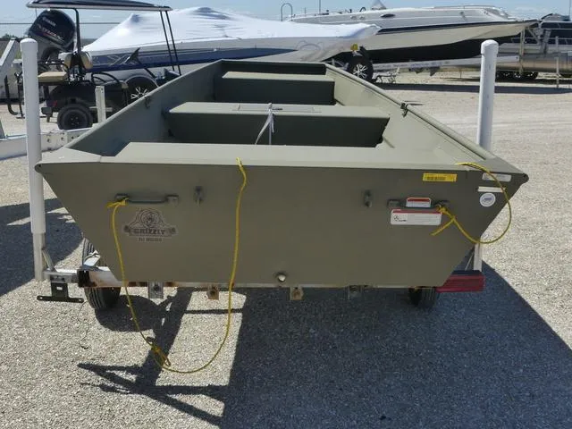 Slide: The Image of 2025 Tracker Grizzly® 15 Jon boat on trailer, parked in a marina. - 5