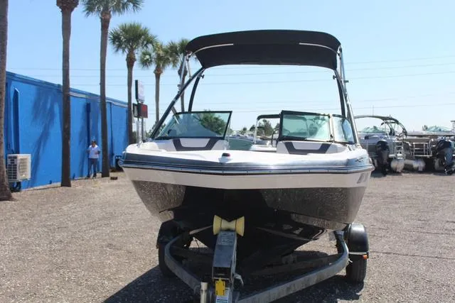 Slide: The Image of 2014 Yamaha AR192 boat on trailer, parked outdoors with palm trees in background. - 2