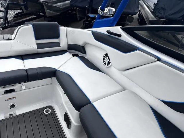 Slide: The Image of 2020 Yamaha AR210 boat interior with sleek white and black seating, blue accents. - 20
