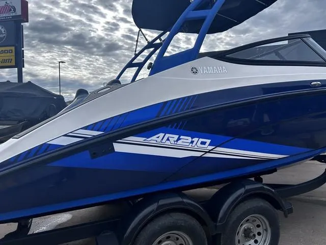 Slide: The Image of 2020 Yamaha AR210 boat with blue and white design on a trailer. - 3