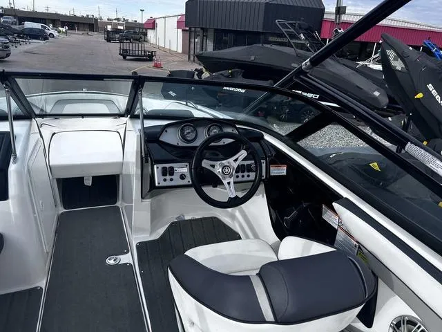 Slide: The Image of 2015 Yamaha Boats AR192 interior with steering wheel and dashboard, parked outdoors. - 10