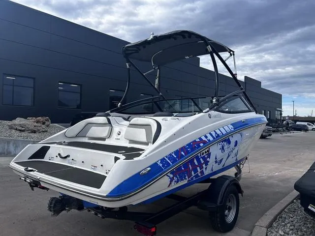 Slide: The Image of 2015 Yamaha Boats AR192 with custom graphics, parked outdoors on a trailer. - 4