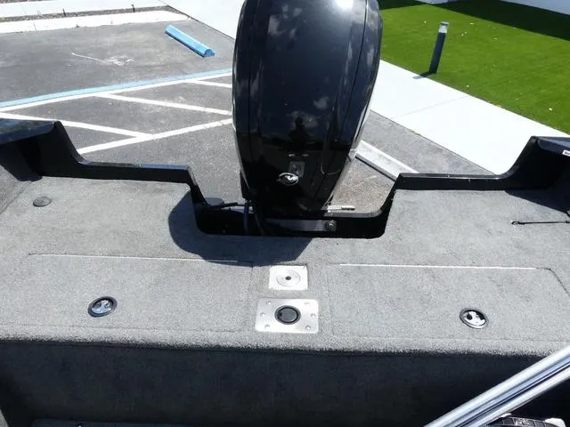 Slide: The Image of 2019 Tracker Pro Guide™ V-165 WT boat deck with motor, parked on pavement. - 12