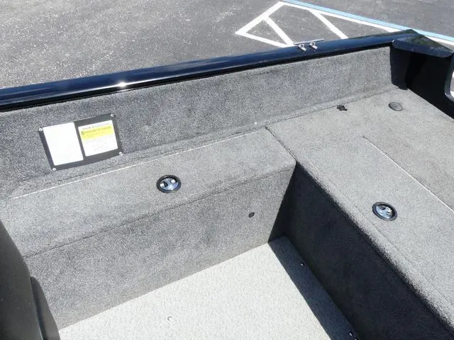 Slide: The Image of 2019 Tracker Pro Guide™ V-165 WT boat interior with gray carpeted seating and storage. - 13
