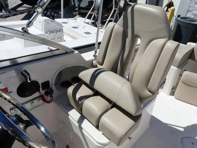 Slide: The Image of 2015 Pursuit Boats DC 235 helm seat with beige upholstery and steering wheel. - 11