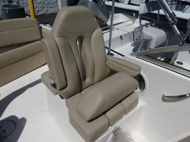 Slide: The Image of 2015 Pursuit Boats DC 235, beige captain's chair, sleek design, comfortable seating, marine setting. - 12