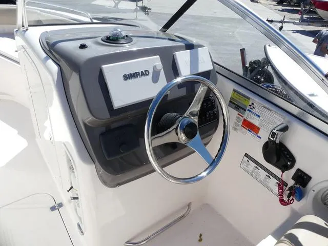Slide: The Image of 2015 Pursuit Boats DC 235 helm with Simrad navigation system and steering wheel. - 9