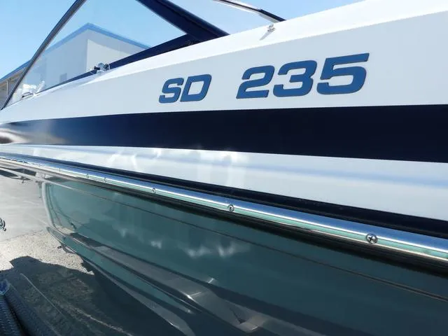 Slide: The Image of 2025 Hurricane SunDeck 235 OB boat, side view with "SD 235" lettering. - 3