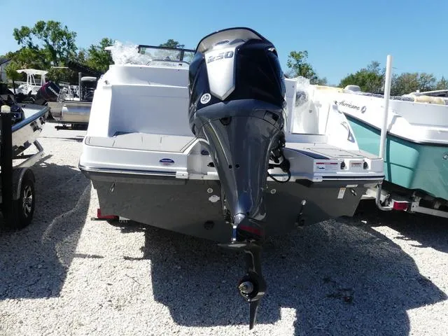Slide: The Image of 2025 Hurricane SunDeck 235 OB boat with powerful outboard motor, parked on gravel. - 6