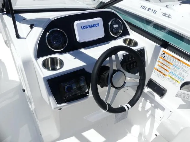 Slide: The Image of 2025 Hurricane SunDeck 235 OB boat dashboard with steering wheel and Lowrance navigation system. - 8