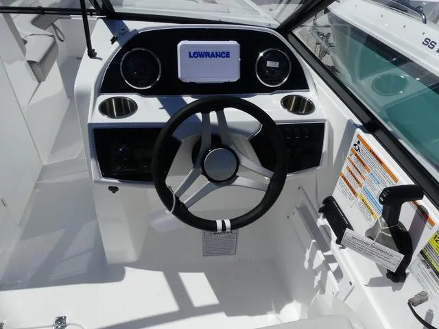 Slide: The Image of 2025 Hurricane SunDeck 235 OB boat dashboard with steering wheel and Lowrance display. - 9
