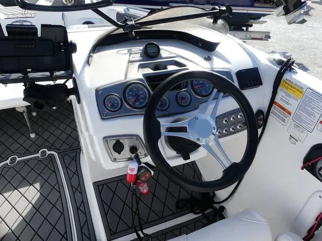 Slide: The Image of 2022 Tahoe 2150 boat dashboard with steering wheel and control gauges. - 10