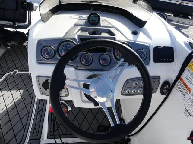 Slide: The Image of Steering wheel and dashboard of 2022 Tahoe 2150 boat with gauges and controls. - 12