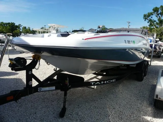 Slide: The Image of 2022 Tahoe 2150 boat on trailer, parked on gravel, under clear blue sky. - 3