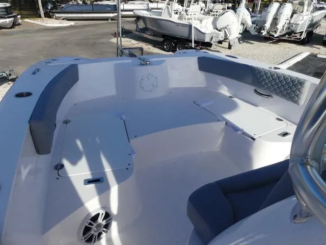 Slide: The Image of 2025 Twin Vee 240 Center Console STX boat with T-top in a sunny parking lot. - 26