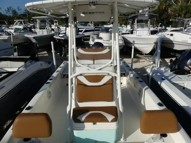 Slide: The Image of 2019 Skeeter SX2250 boat with brown and white seating, docked among other boats. - 18