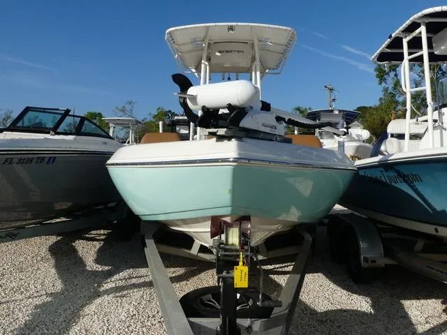 Slide: The Image of 2019 Skeeter SX2250 boat on trailer, parked between other boats, under clear blue sky. - 2