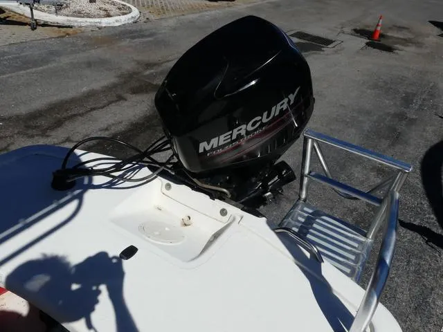 Slide: The Image of 2014 Mako Pro 17 Skiff CC with Mercury outboard motor in a parking area. - 13