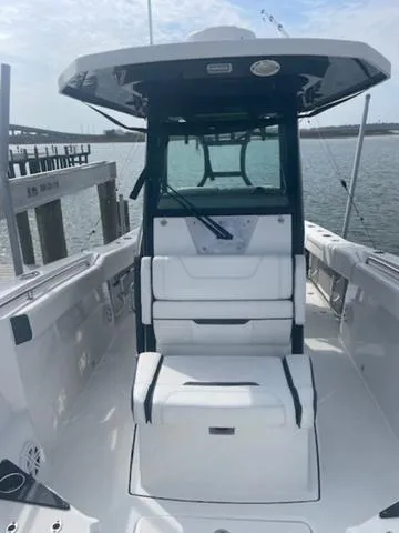 Slide: The Image of 2022 Blackfin 272CC boat with sleek design, spacious seating, and modern features on the water. - 11