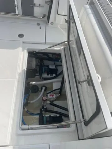 Slide: The Image of 2022 Blackfin 272CC boat interior showing open storage compartment with visible equipment. - 8
