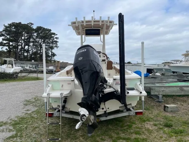 Slide: The Image of 2023 Pioneer 220 Bay Sport boat with outboard motor, parked on grass. - 4