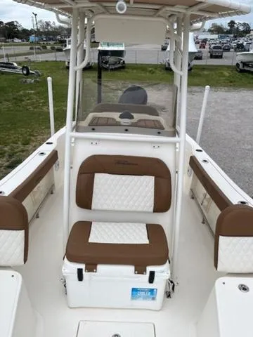 Slide: The Image of 2023 Pioneer 220 Bay Sport boat interior with cushioned seating and storage. - 8