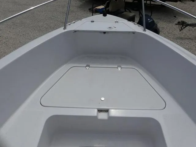 Slide: The Image of 2002 Pro-Line 22 Sport boat deck with storage compartment, white finish, and metal railings. - 12