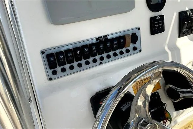 Slide: The Image of Control panel of a 2018 Key West 239FS boat with steering wheel and switches. - 13