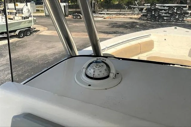 Slide: The Image of 2018 Key West 239FS boat with Ritchie compass on deck, parked near trailers. - 16