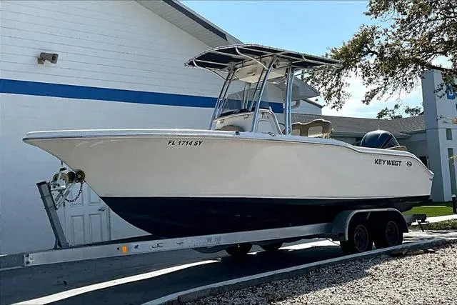 Slide: The Image of 2018 Key West 239FS boat on trailer, parked outdoors near a building. - 33