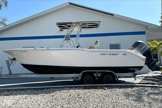 Slide: The Image of 2018 Key West 239FS boat on trailer, parked beside a house. - 4