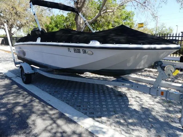 Slide: The Image of 2019 Bayliner Element E18 boat on trailer with cover, parked outdoors. - 1