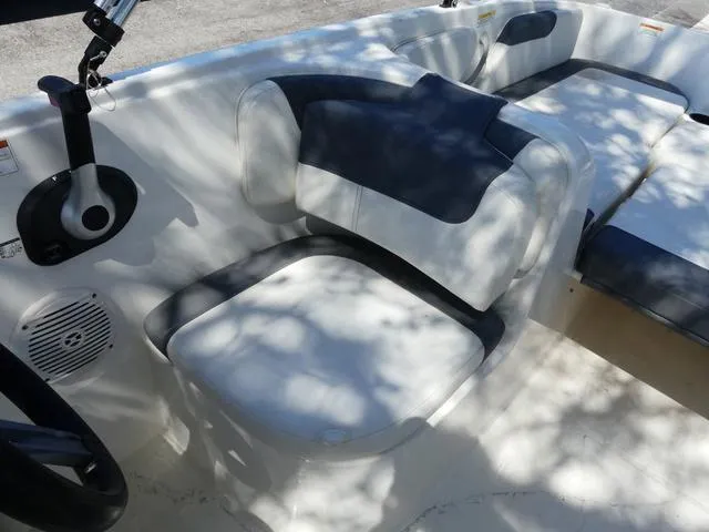 Slide: The Image of 2019 Bayliner Element E18 boat interior with cushioned seating and steering wheel. - 6