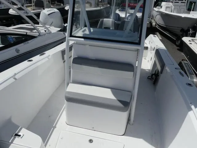 Slide: The Image of 2021 Release 240 RX boat interior with seating and console, docked among other boats. - 13