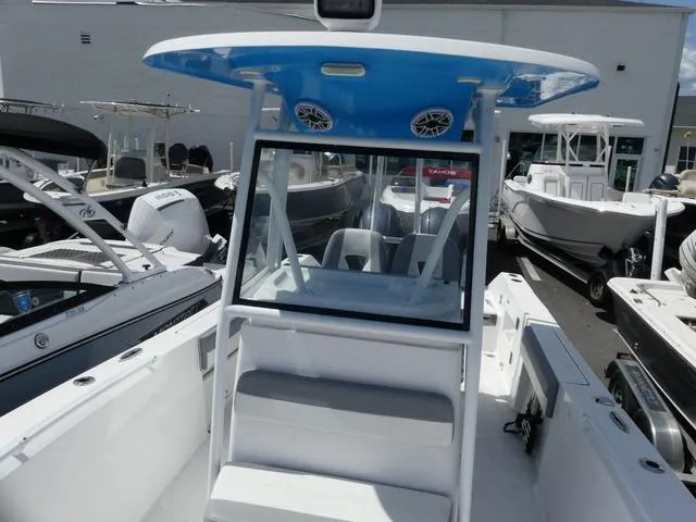 Slide: The Image of 2021 Release 240 RX boat with blue T-top and seating, displayed at a marina. - 14