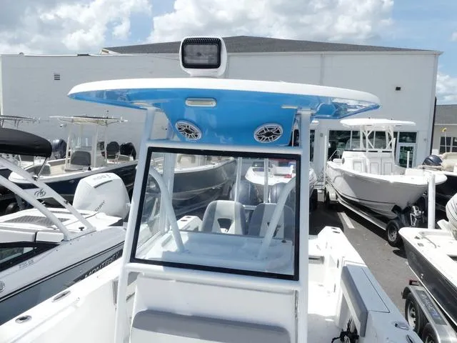 Slide: The Image of 2021 Release 240 RX boat with blue T-top, docked among other boats. - 15