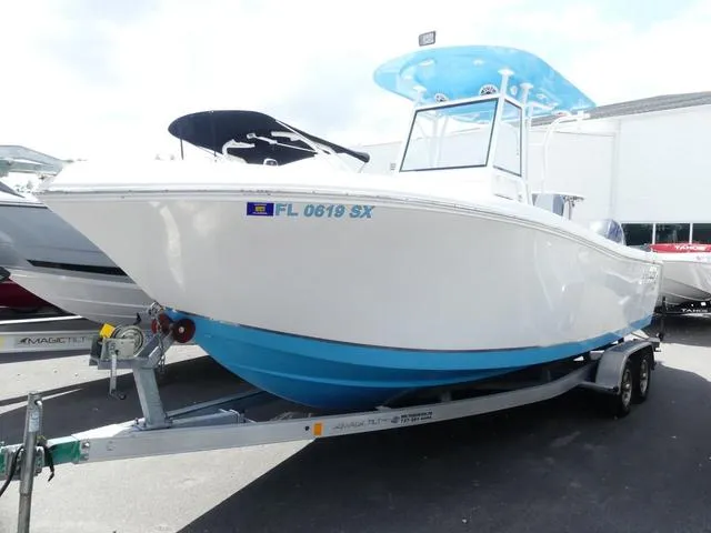 Slide: The Image of 2021 Release 240 RX boat on trailer, white and blue design, parked outdoors. - 3