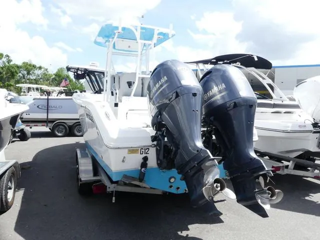 Slide: The Image of 2021 Release 240 RX boat with twin Yamaha outboard motors in a marina. - 4