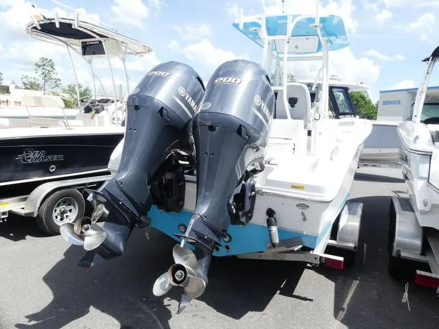 Slide: The Image of 2021 Release 240 RX boat with twin Yamaha 200 engines, docked under a clear sky. - 6