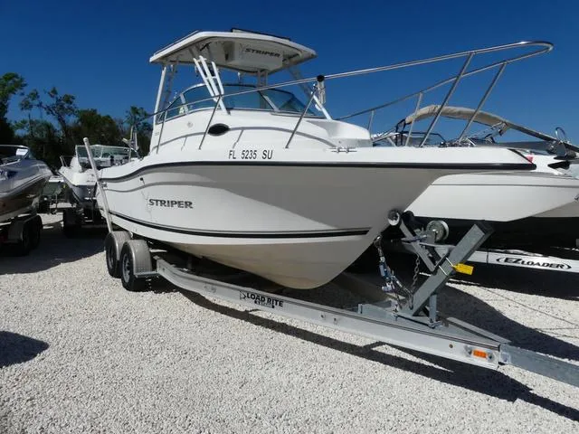 Slide: The Image of 2002 Seaswirl Striper 2301 boat on trailer, parked on gravel lot. - 1