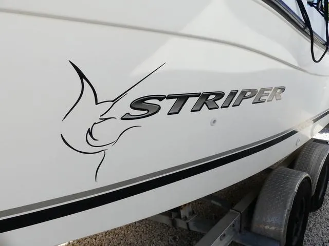 Slide: The Image of 2002 Seaswirl Striper 2301 boat side view with logo and graphic design. - 4