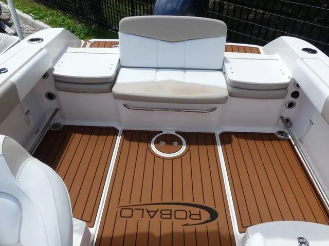 Slide: The Image of 2019 Robalo R207 boat interior with cushioned seating and teak-style flooring. - 11