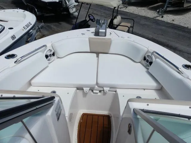 Slide: The Image of 2019 Robalo R207 boat interior with white seating and wood flooring. - 13