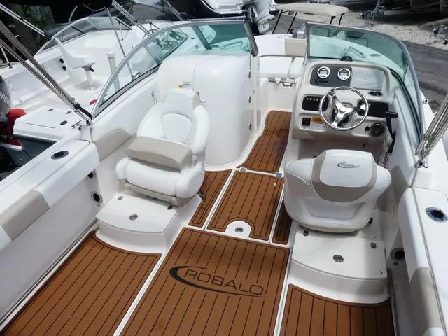Slide: The Image of 2019 Robalo R207 boat interior with wood flooring and white seating. - 15