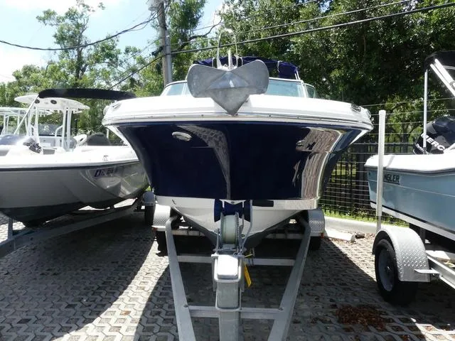 Slide: The Image of 2019 Robalo R207 boat on trailer, front view, parked outdoors. - 2